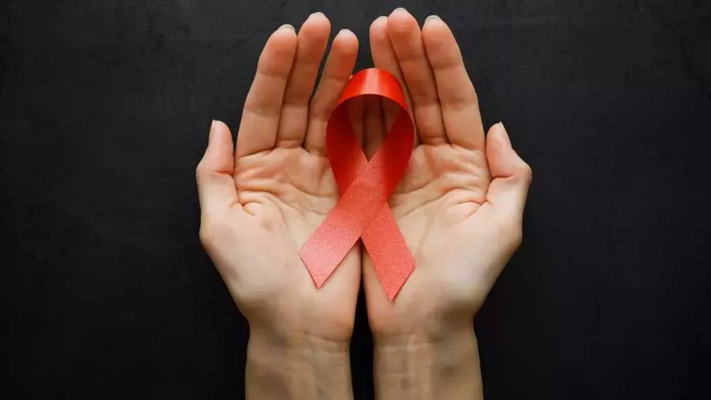 manos sosteniendo un lazo rojo