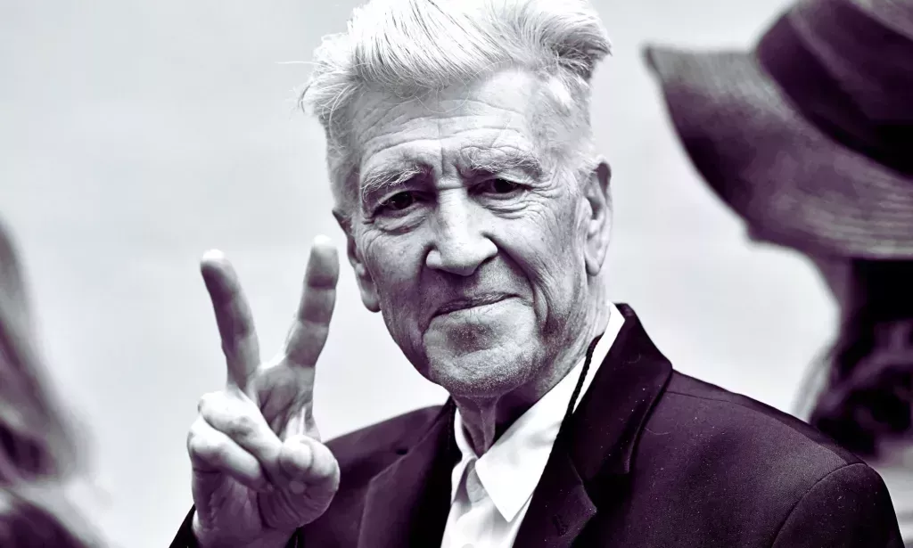 David Lynch throwing a peace symbol.