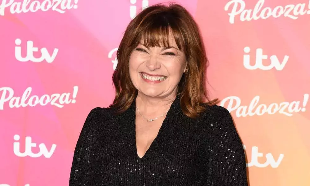 Lorraine Kelly sonríe a la cámara mientras viste un atuendo negro brillante