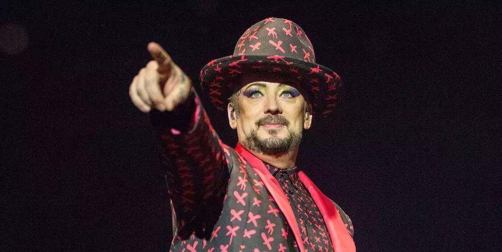 Boy George actuando con un traje y un sombrero de patrones rojo y negro