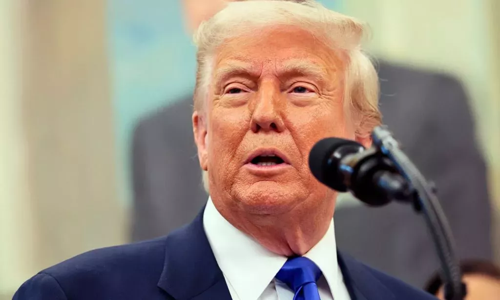 Donald Trump hablando en un micrófono.