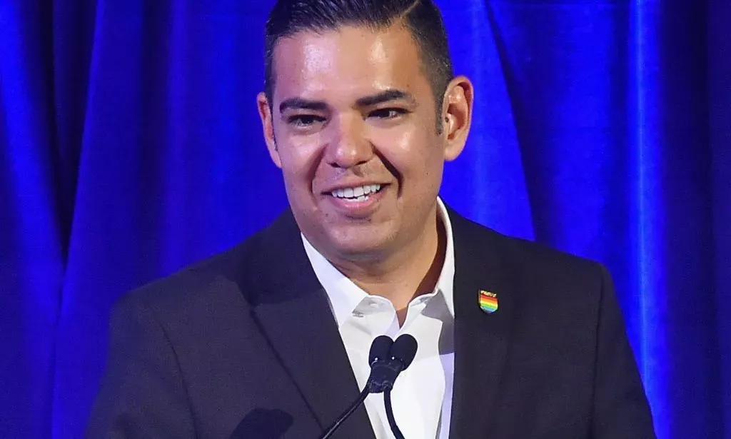 Robert Garcia, vestido con traje, hablando en un evento.