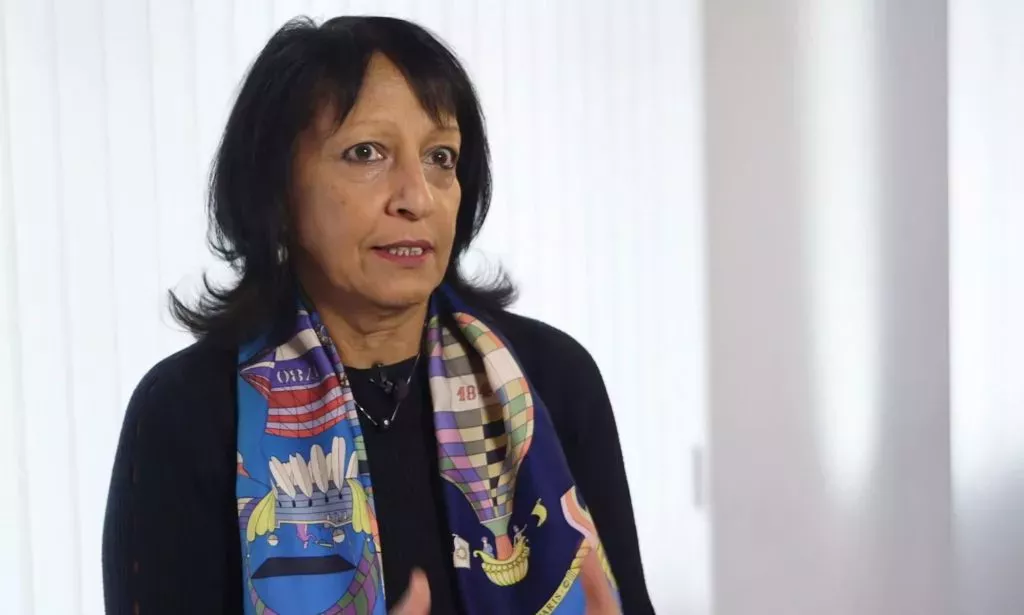 Kishwer Falkner, hablando en una sala blanca.