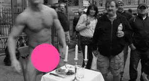 Un artista musculoso desnudo y come en medio de la calle